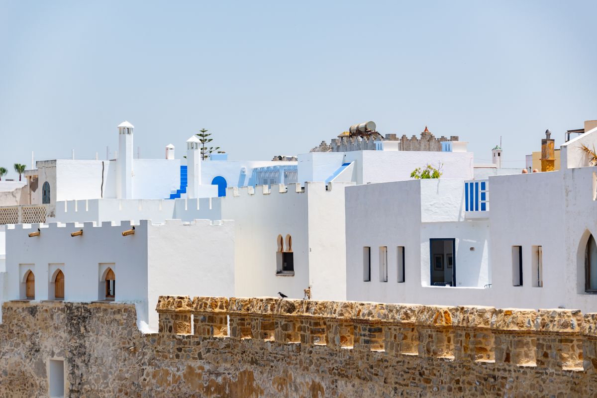 Traditional white and blue buildings under a clear sky in the medina of Asilah, Morocco