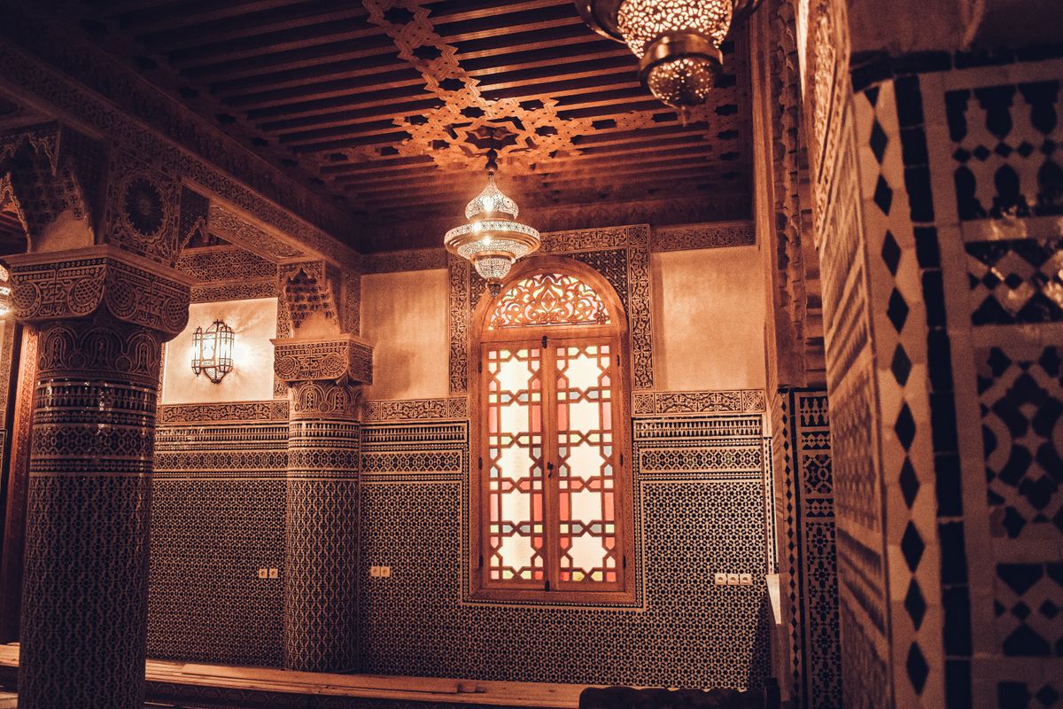 A traditional Moroccan interior with intricate zellige mosaics and carved decoration in Fes, Morocco