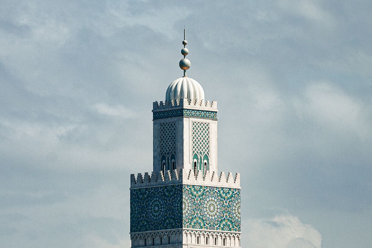 Minaret of the Hassan II Mosque in Casablanca, Morocco, against white clouds
