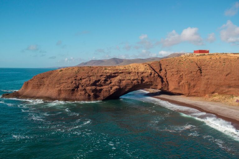 Red sandstone arch and turquoise ocean at Legzira Beach near Sidi Ifni, Morocco