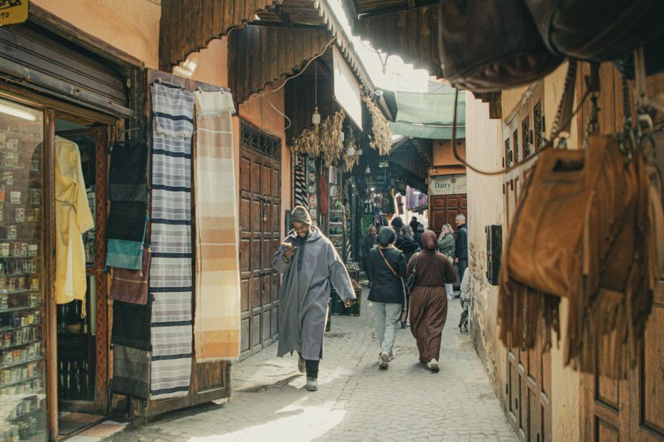 A busy market street in the Marrakech medina, Morocco, with shoppers and stalls