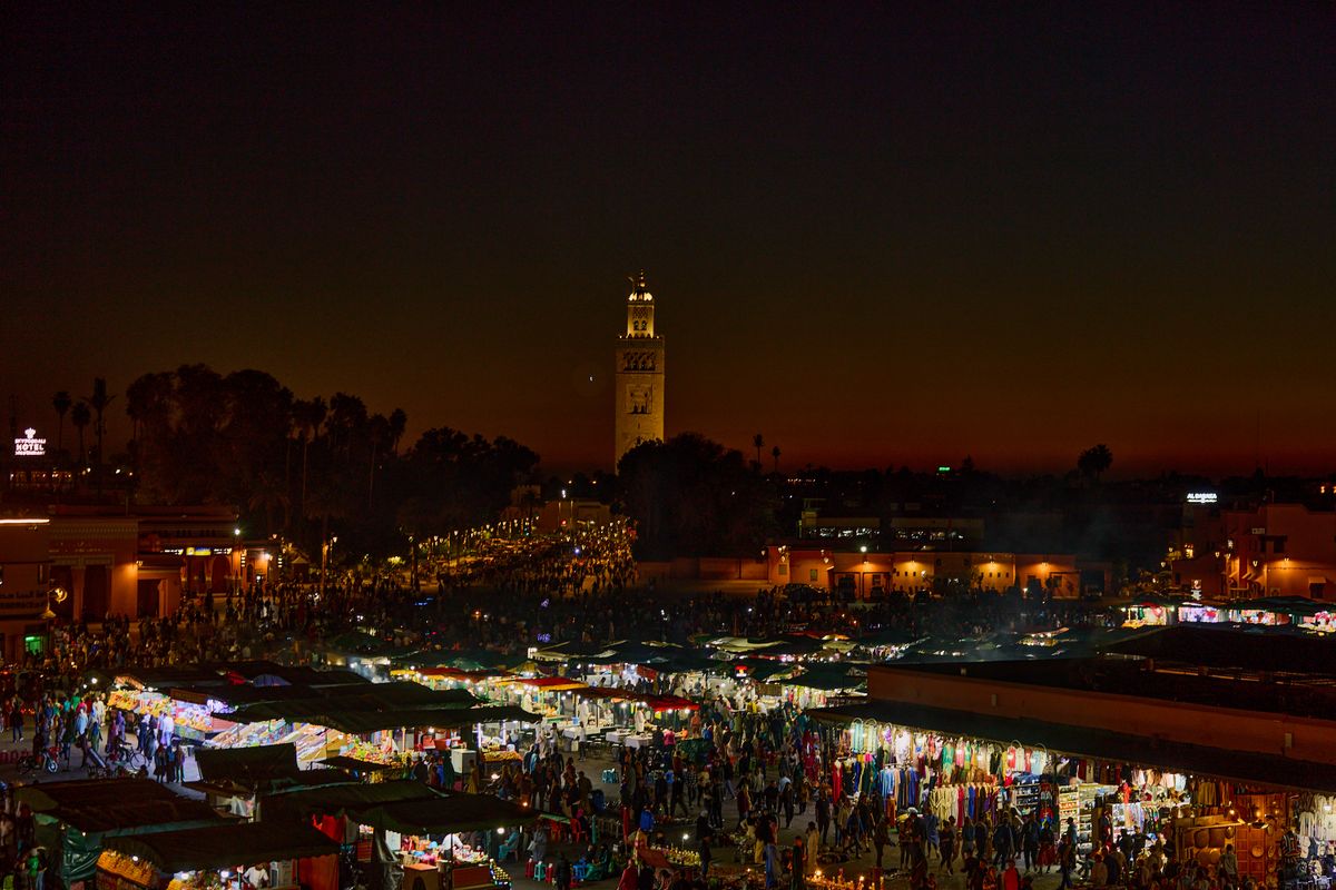 The night market of Jemaa el-Fna in Marrakech, Morocco, lit up at twilight