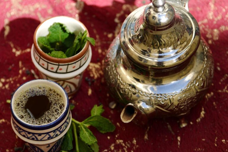 Moroccan mint tea set with a silver teapot and glasses on a red rug in Fes, Morocco