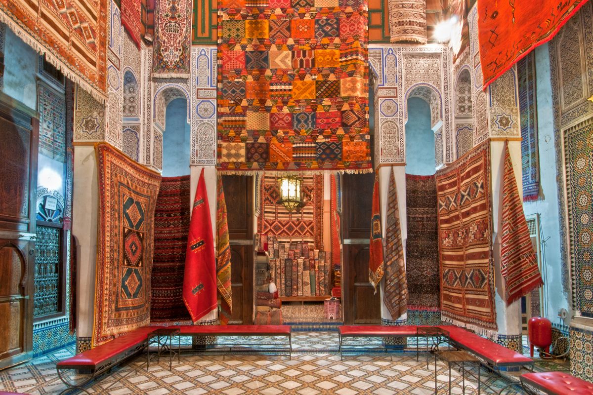 Colourful Moroccan rugs on display in a traditional shop in the Fes medina, Morocco