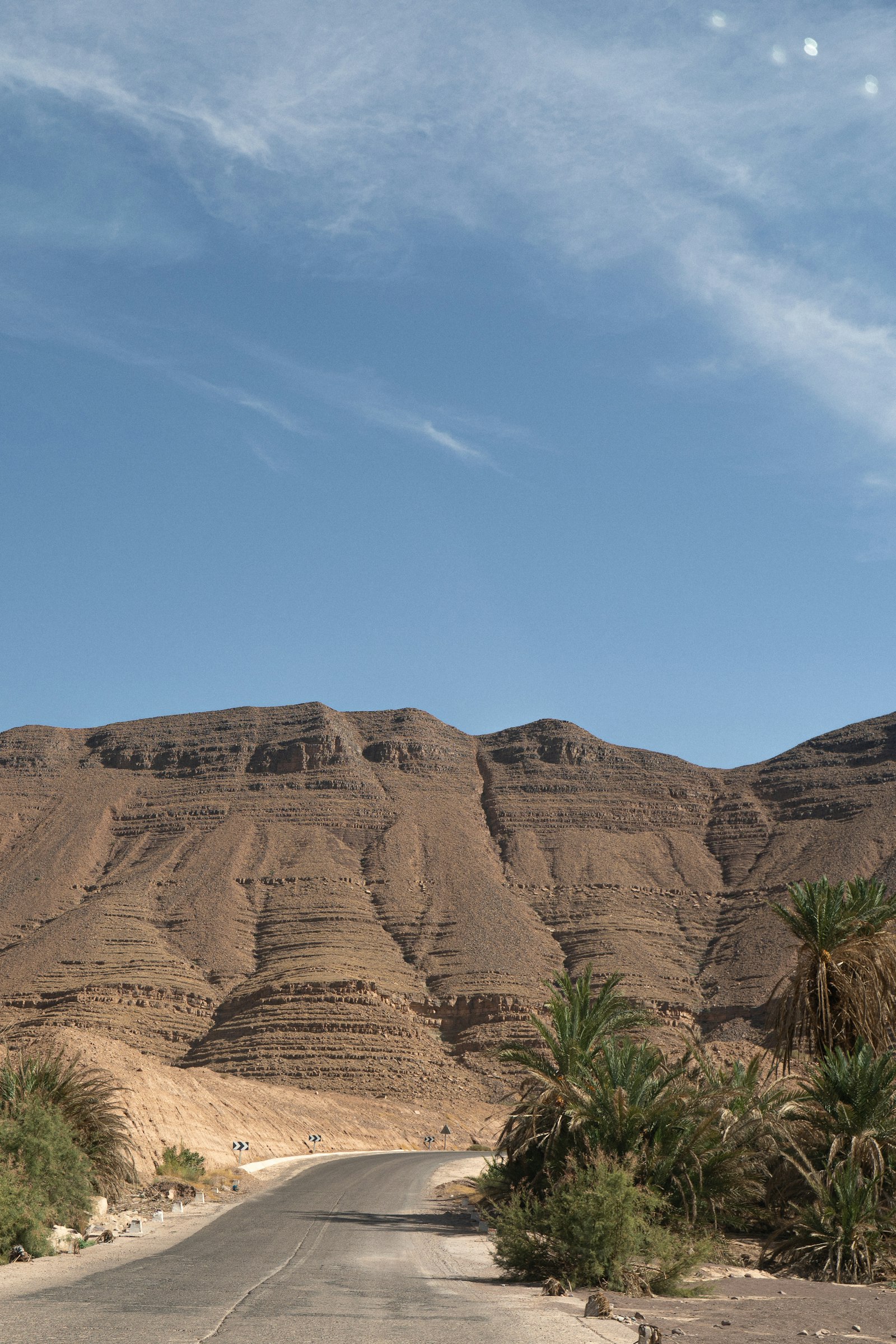 Road crossing a desert landscape with mountains in Morocco
