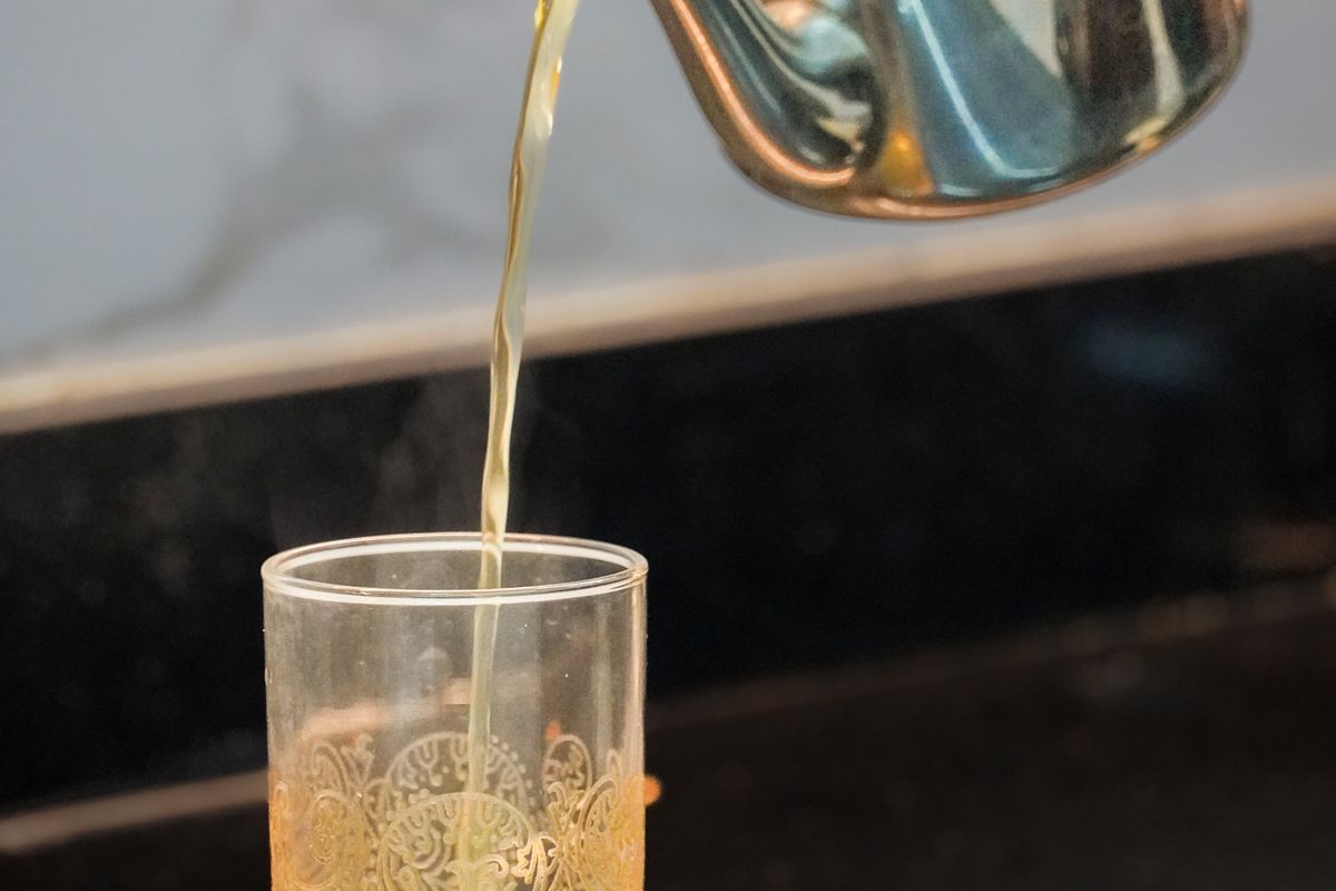 Moroccan mint tea poured from a silver teapot into a decorated glass in Casablanca, Morocco