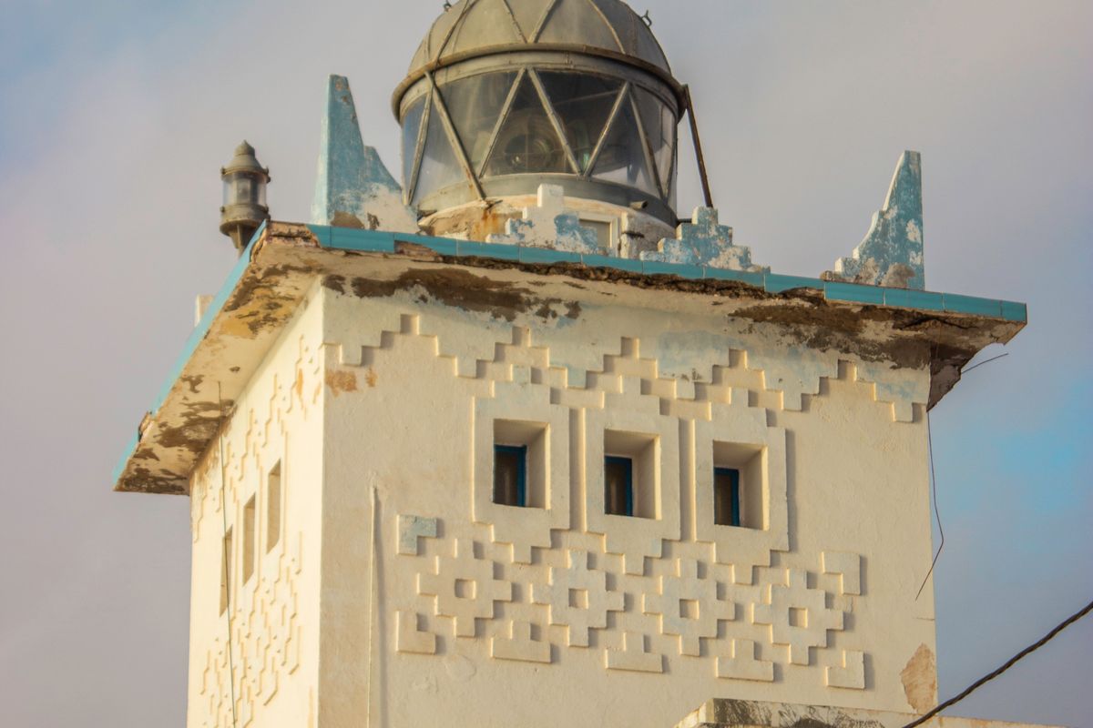 Decorated facade of the Sidi Ifni lighthouse under a clear blue sky, Morocco