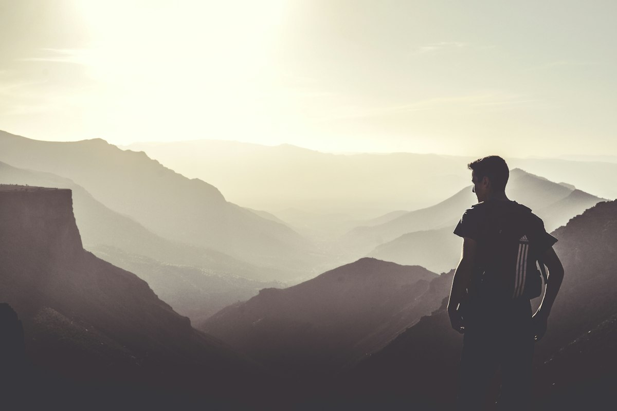 Hiker standing on top of a granite mountain near Tafraoute, Anti-Atlas, Morocco