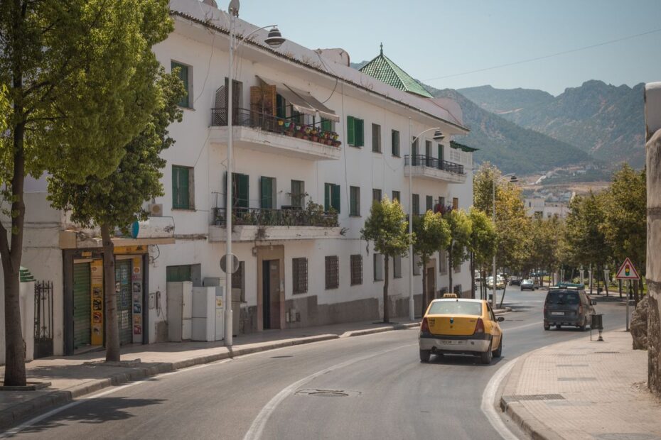 White buildings along a street in Tetouan, Morocco, with the Rif mountains behind
